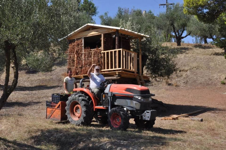 old man driving tractor and says hello to the camera around 'Lithies Organic Farm'