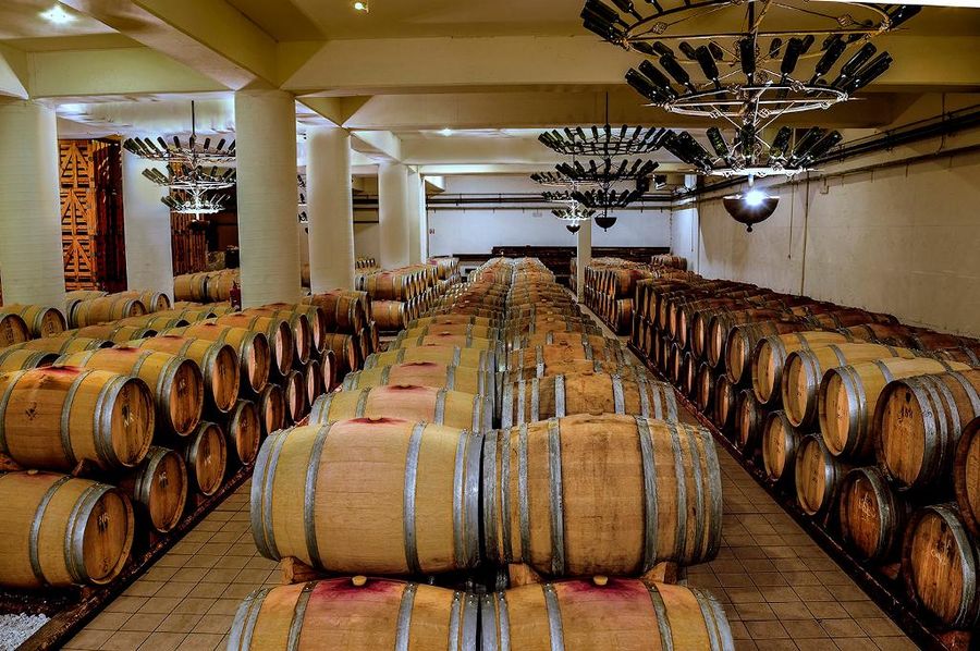 lying wooden barrels in a row on top of each other at Semeli Estate cellar with columns