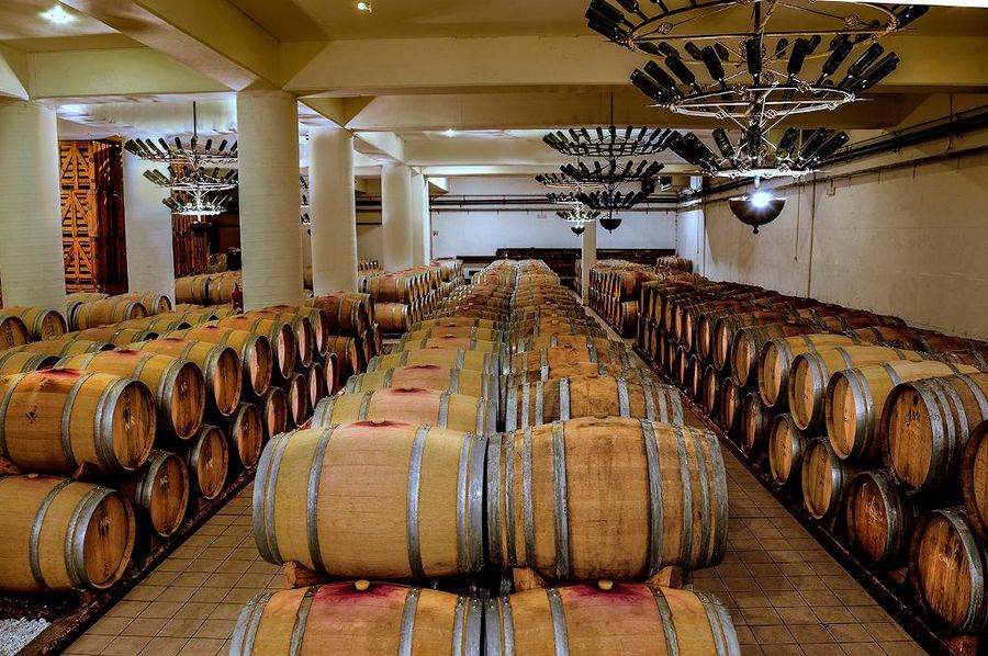 lying wooden barrels on top of each other at Semeli Estate cellar