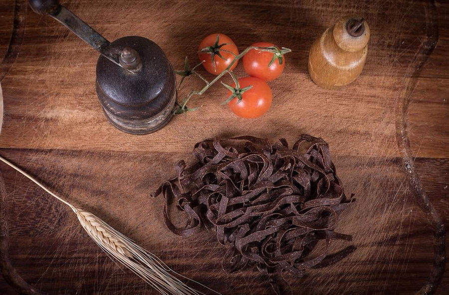 hilopites pasta with cuttlefish ink on wood plateau at Maggiri