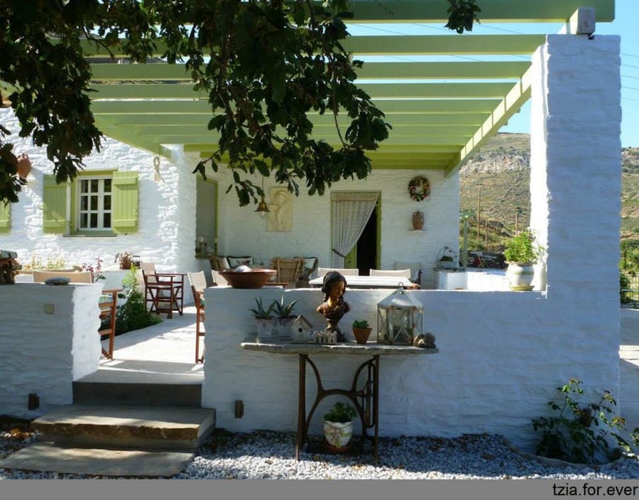 front view of 'La Maison Vert Amande' building with terrace covered with wood pergola