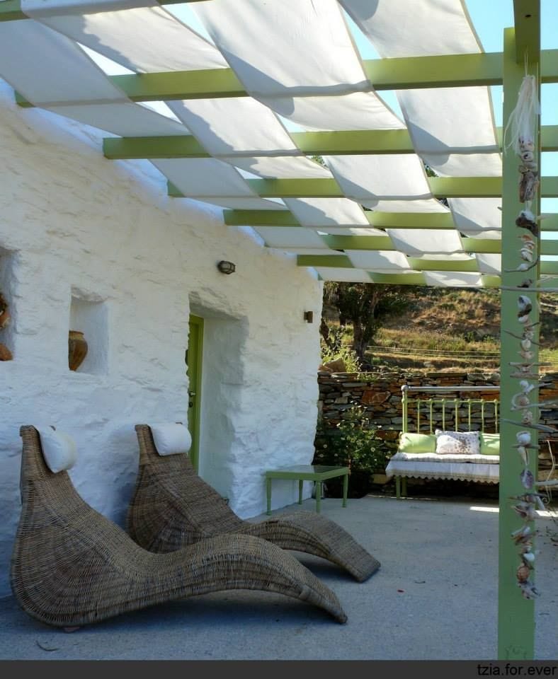 'La Maison Vert Amande' building with terrace covered with wood pergola and two lounge chairs