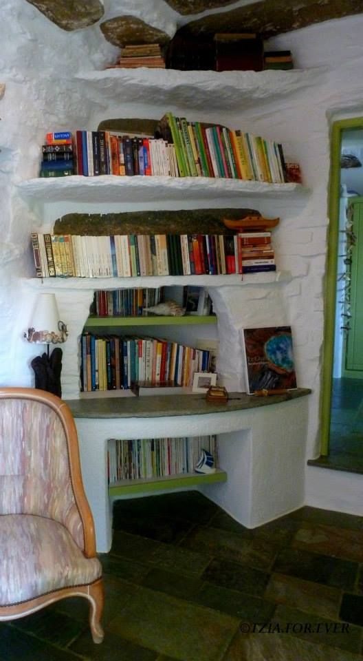 corner in 'La Maison Vert Amande' room with stone shelves with books