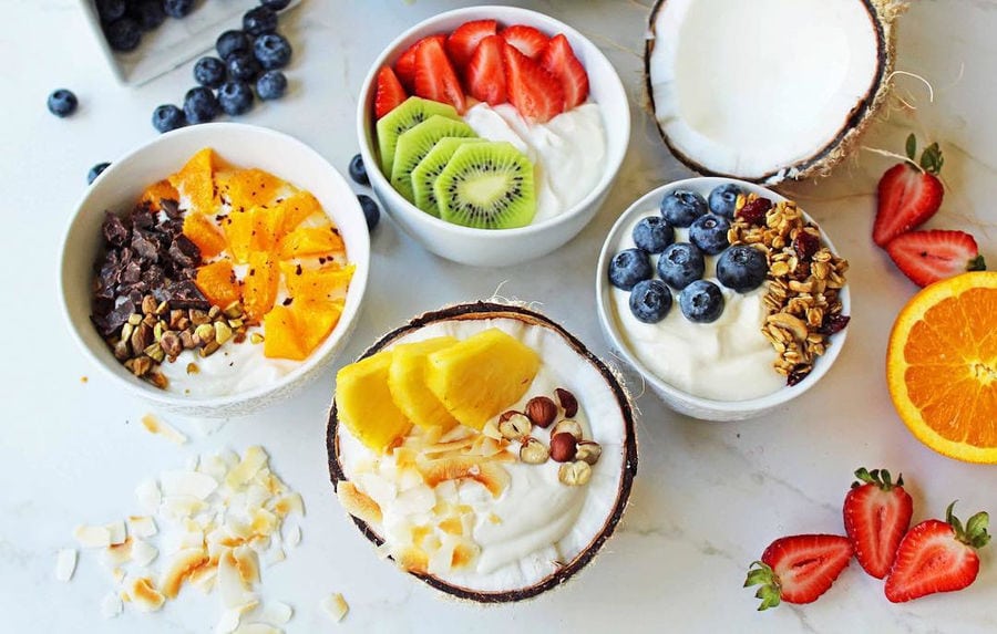 view from above of bowls with Mandrekas Greek Yogurt vanilla creams and nuts and peces of pears and raspberry on the top