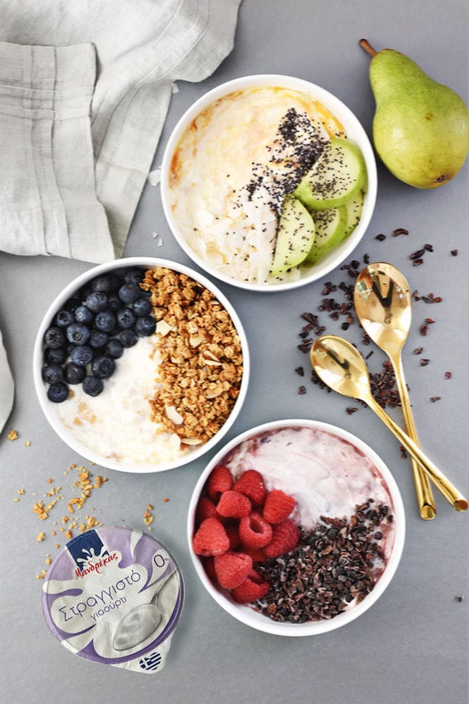 view from above of bowls with Mandrekas Greek Yogurt vanilla creams and nuts and peces of pears and raspberry on the top