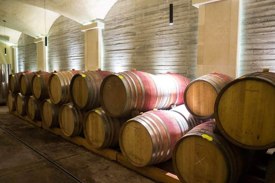 wine wood barrels on top of each other in a row at Manousakis Winery cellar