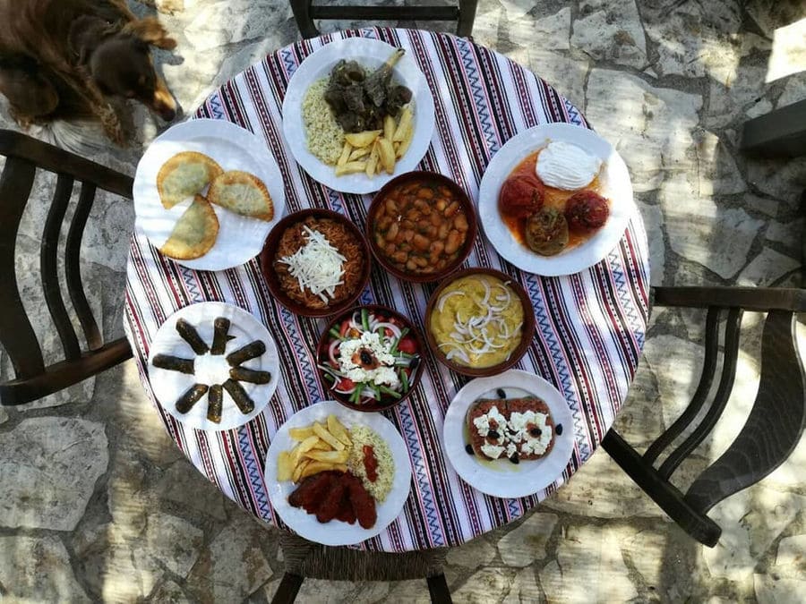 view from above of a table with folklore tablecloth and plates with cooked foods at Manousakis Winery restaurant