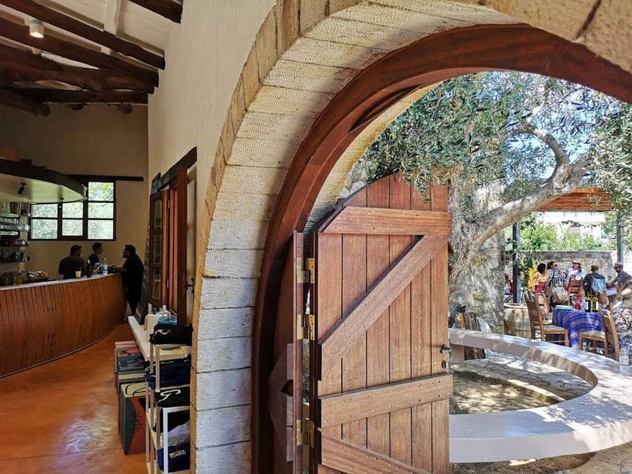 Manousakis Winery entrance with stone arcade and wood open door