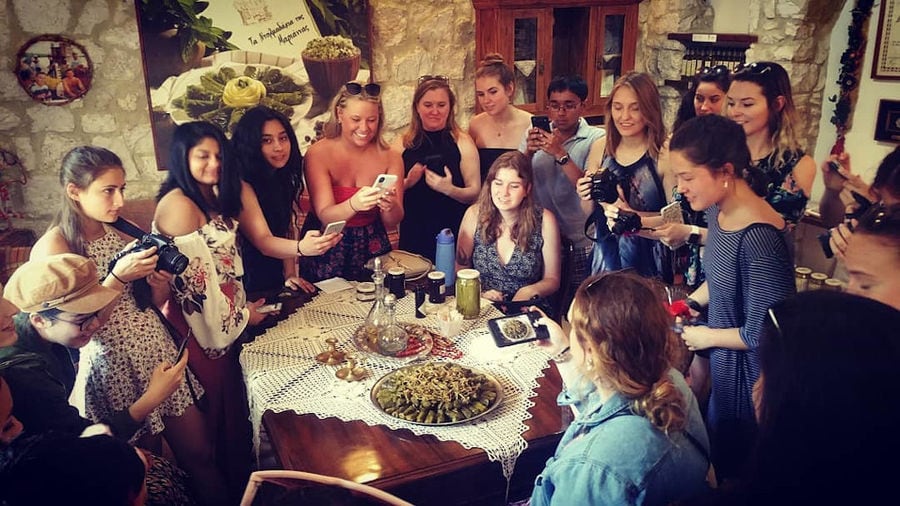group of young women taking photos with cameras cooked Greek dolmades at 'Marianna'