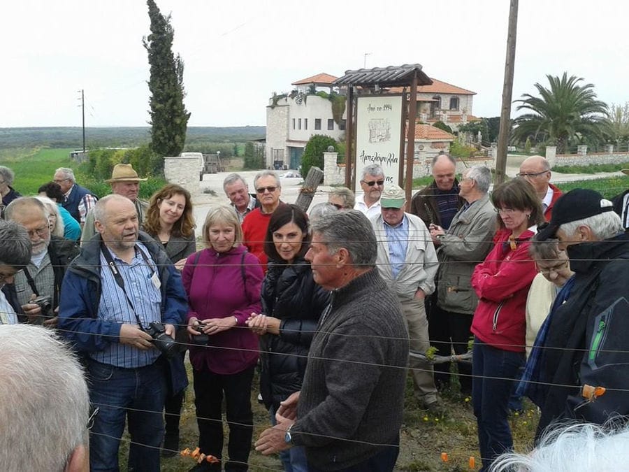 a group of tourists listening to a man giving a tour at 'Marianna' crops