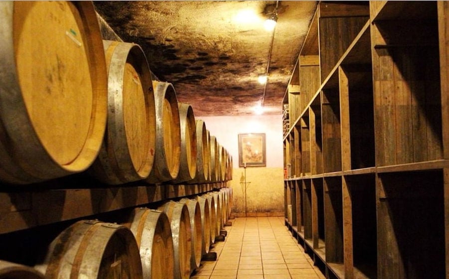 wine wood barrels on top of each other at 'Mercouri Estate' stone cellar