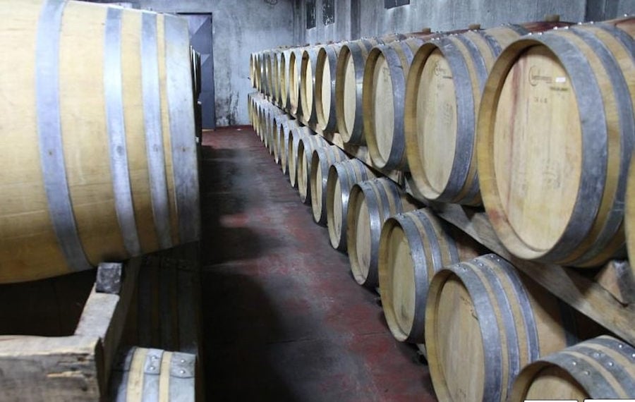 wine wood barrels on top of each other at 'Mercouri Estate' stone cellar