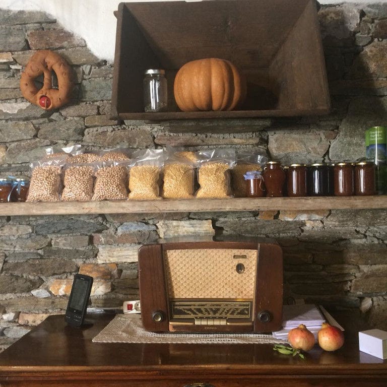 old radio and various pasta and jars on the shelves on the stone wall at 'Narlis Farm'
