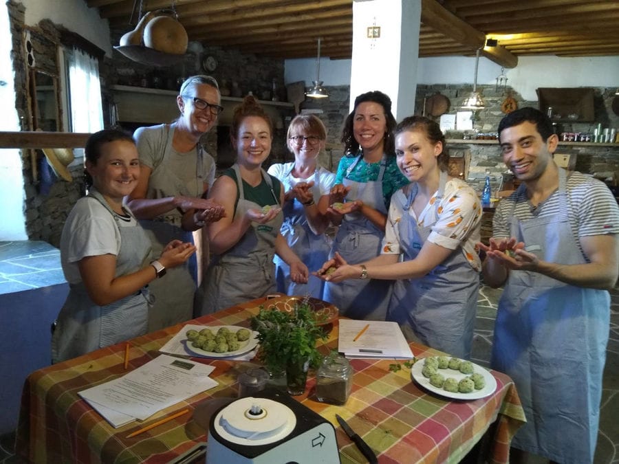 tourits dressed with aprons and smiling happily at the camera at 'Narlis Farm' around the table