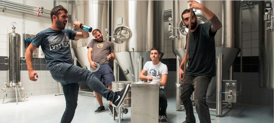 four men happily and mimic that they singing at Noctua Brewery plant