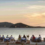 People eatin by the sea in a tavern