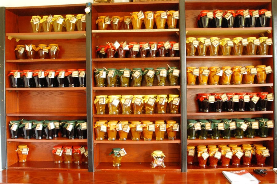 glasses jars with 'Voskopoulos Handicraft' marmalades on the shelves of wardrobe