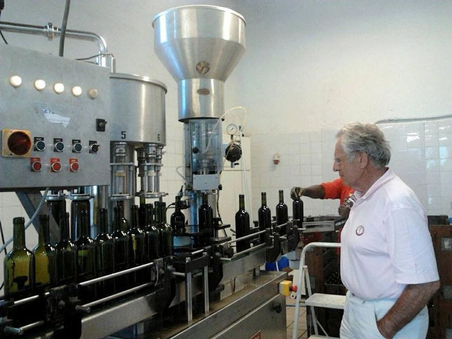 old oenologist using wine packaging machine at Ktima Kokotou plant