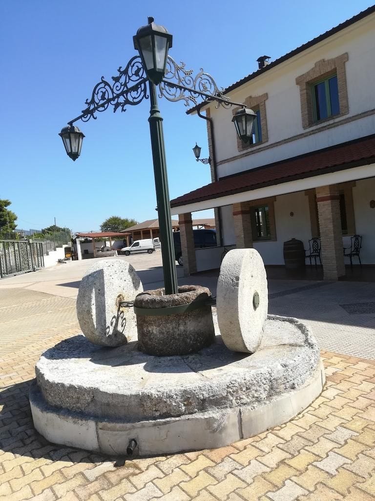 old stone olive press and a street lamp front at Tzivani Bio Wines outside