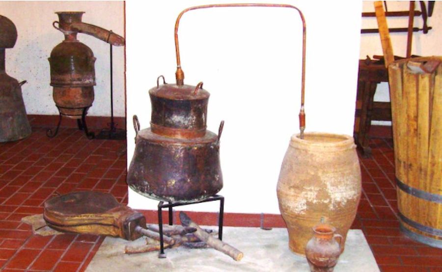 old traditional bronze distillation cauldron with a pipe connected with and an amphora at Tzivani Bio Wines