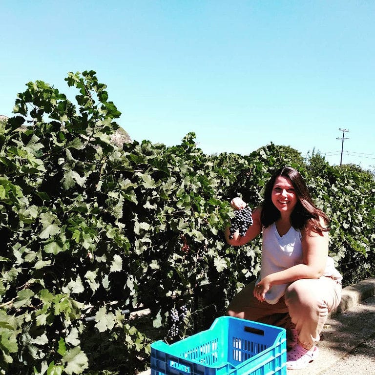 girl with long hair smiling happily at the camera at Olympia Land Estate vineyards