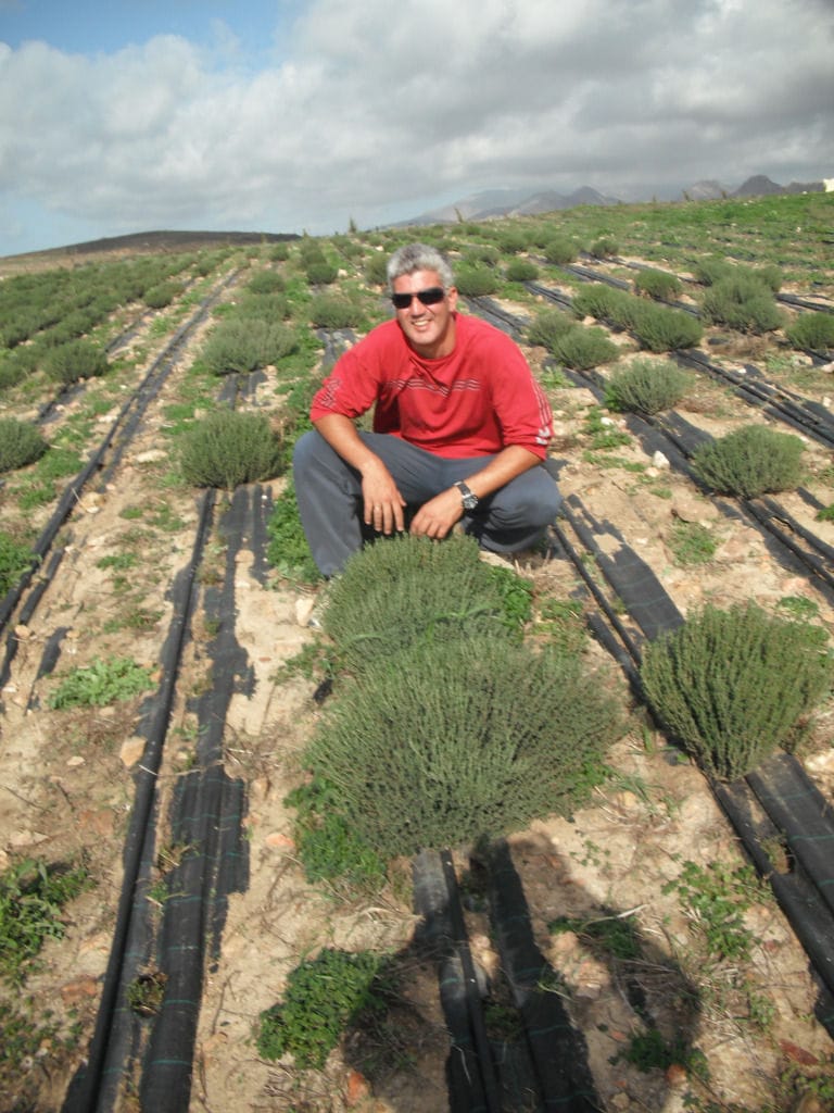 man with glasses smiling happily at the camera at 'Organic Islands' crops