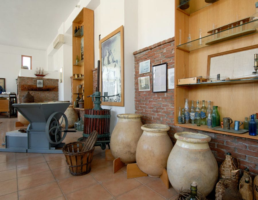 old manual press grape and Greek ceramic amphoras at Ouzo Barbayanni museum