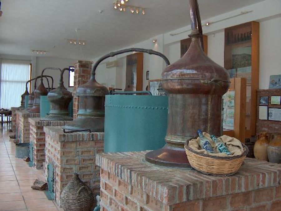 row of old stills on stone basses at The Ouzo Barbayanni Museum