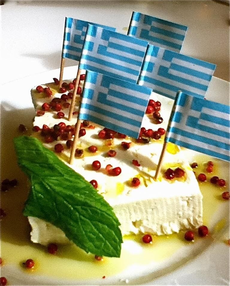 piece of feta cheese with Greek flags on it and red peppercorns from Greek Cooking Class from Two Minutes Angie