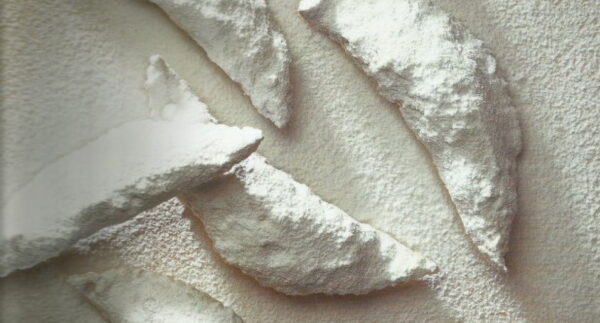 Close-up of ‘psarakia’ made with a thin sheet of pastry cut into strips of stuffing folded into the shape of a small fish sprinkled with powdered sugar