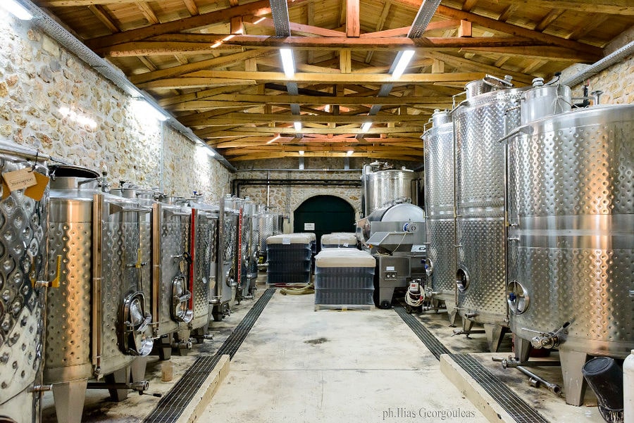 large corridor with aluminum wine storage tanks on the both sides at Pyrgos Vasilissis winery plant