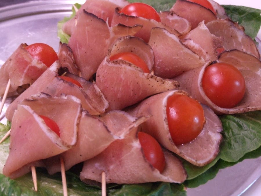 folded louza with tomato cherries inside held with wooden toothpicks at 'Roussounelos Meat Market'