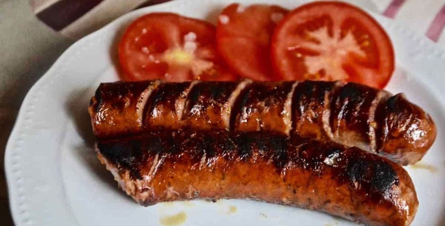 grilled pork sausage and tomato slices on white plate at 'Roussounelos Meat Market'