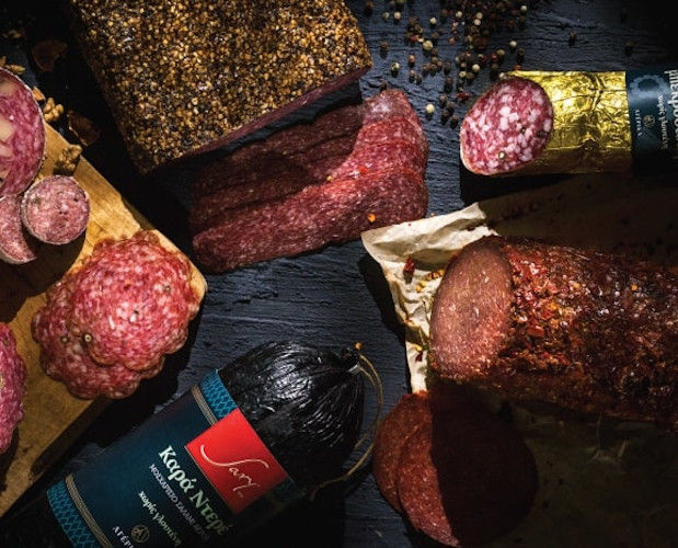 close-up and from above of various types of salami and peppercorns on black surface at 'Sary'