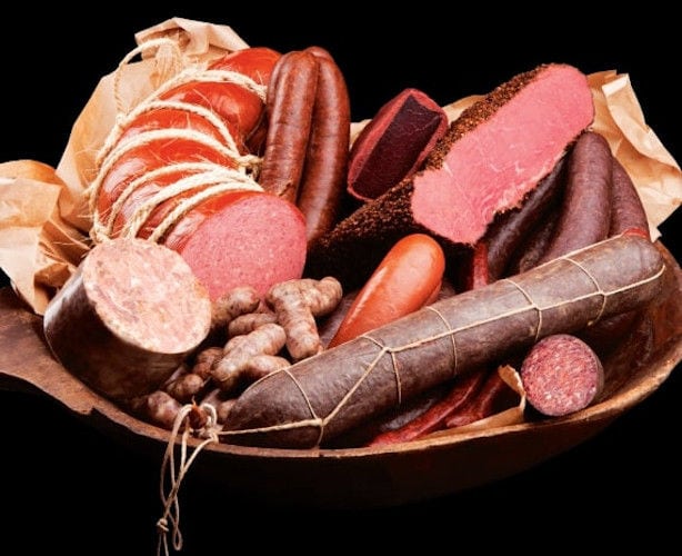 wooden plateau with pieces of processed meat, sausages and various types of salami at 'Sary'