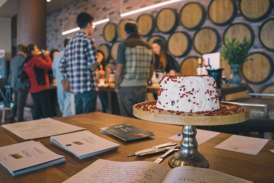 cake with whipped cream on background of tourists tasting wines at 'Semeli Estate' winery