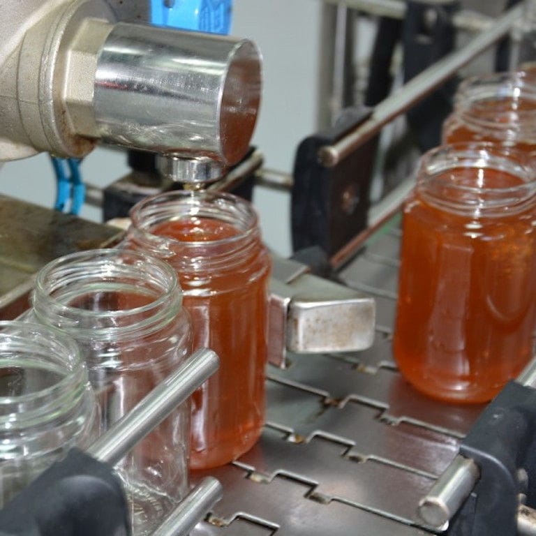 close-up of part of honey filling machine working at 'Si-Mel Honey Toplou' plant