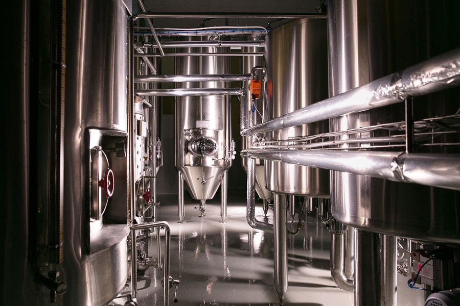 view of the base of aluminum beer tanks at 'Sknipa' plant