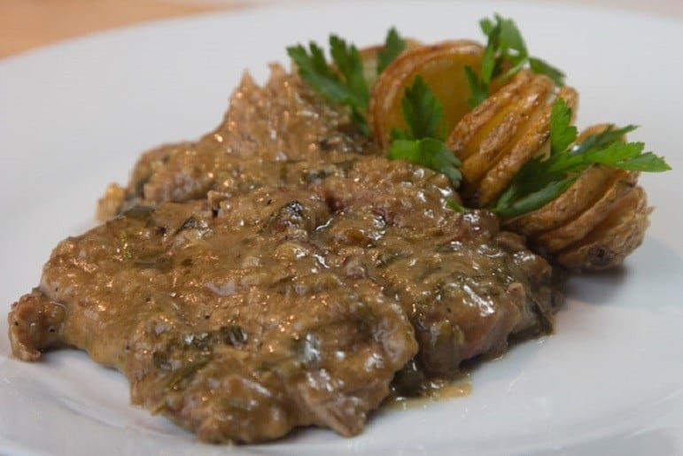 Plate with Greek ‘Sofrito’ made from beef coated in flour served with French fries