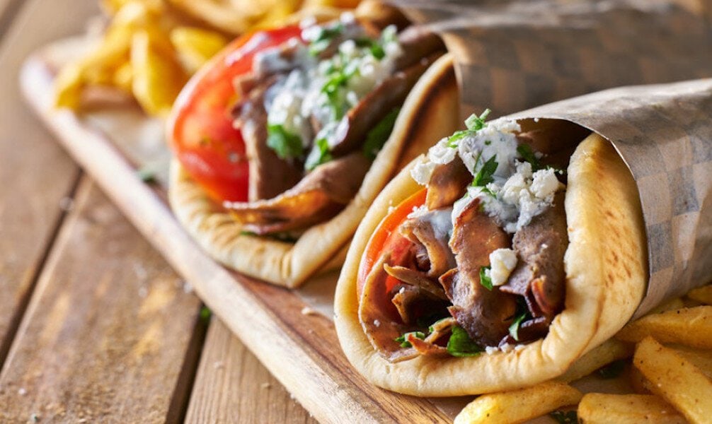 Greek ‘souvlaki’ with pitta bread, grilled chunks of meat with ‘tzatziki’ yogurt, fried potatoes and piece of tomato 