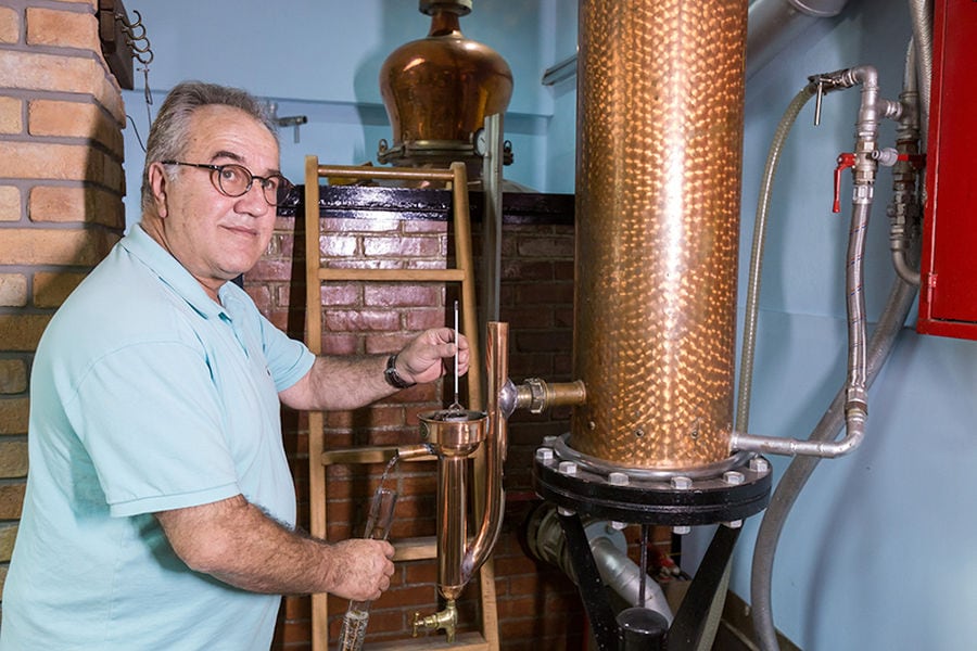 man taking sample alcohol from distillery equipment spirits at 'Spentza Distillery'