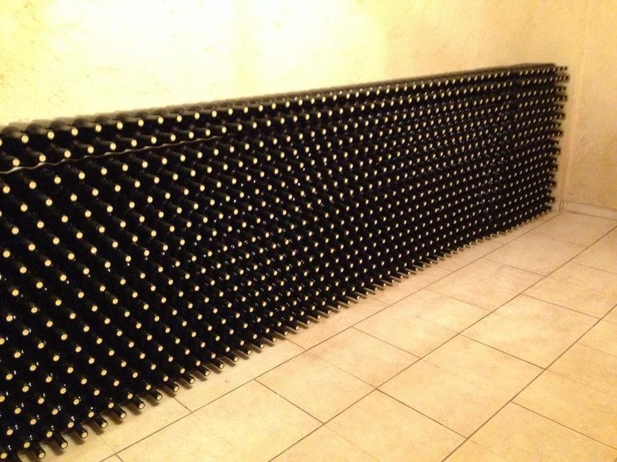 stacked bottles on top of each other storaged in the wall of 'Stilianou Winery' cellar