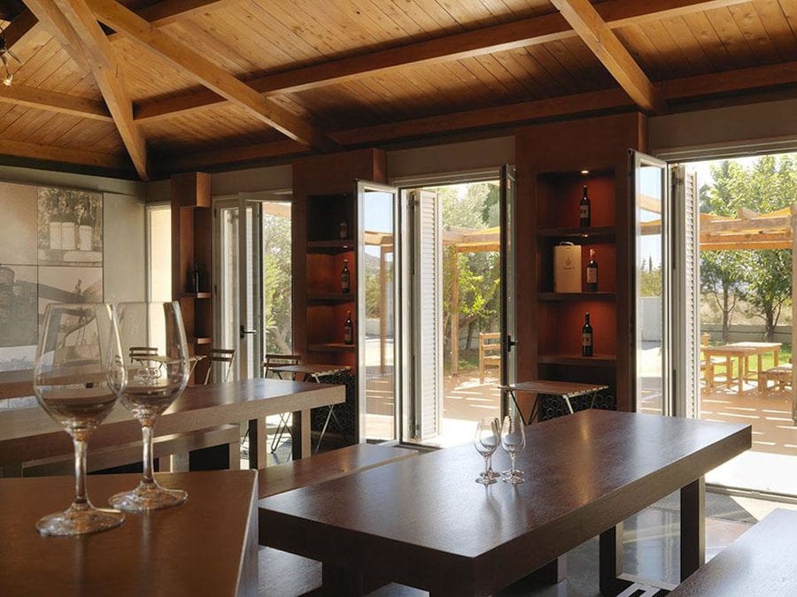 Strofilia winery tasting room with wood tables and open doors