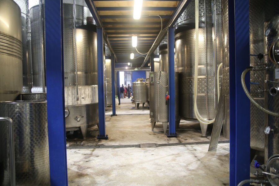 two rows of lying aluminum wine storage tanks at Strofilia winery plant