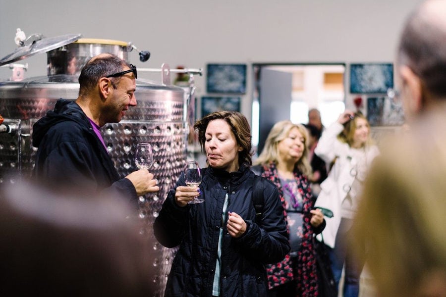 Tourists enjoy a wine tasting at Strofilia winery tanks area