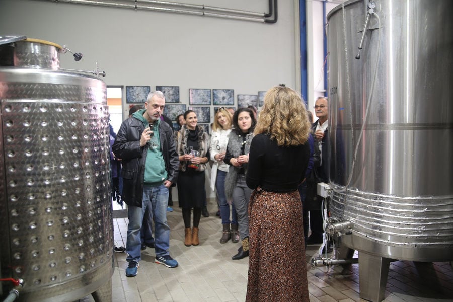 Tourists visiting the Strofilia winery in the tanks area and listening to a guide