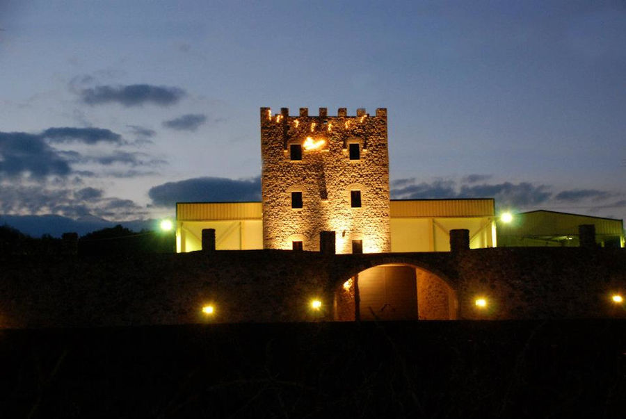 front side of the stone tower of 'Theodorakakos Estate winery' at night