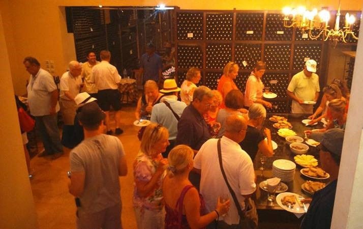 Tourists eating and enjoy a wine tasting at 'Theodorakakos Estate' cellar
