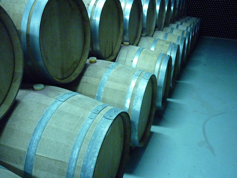 wine wood barrels on top of each other at 'Theodorakakos Estate' cellar