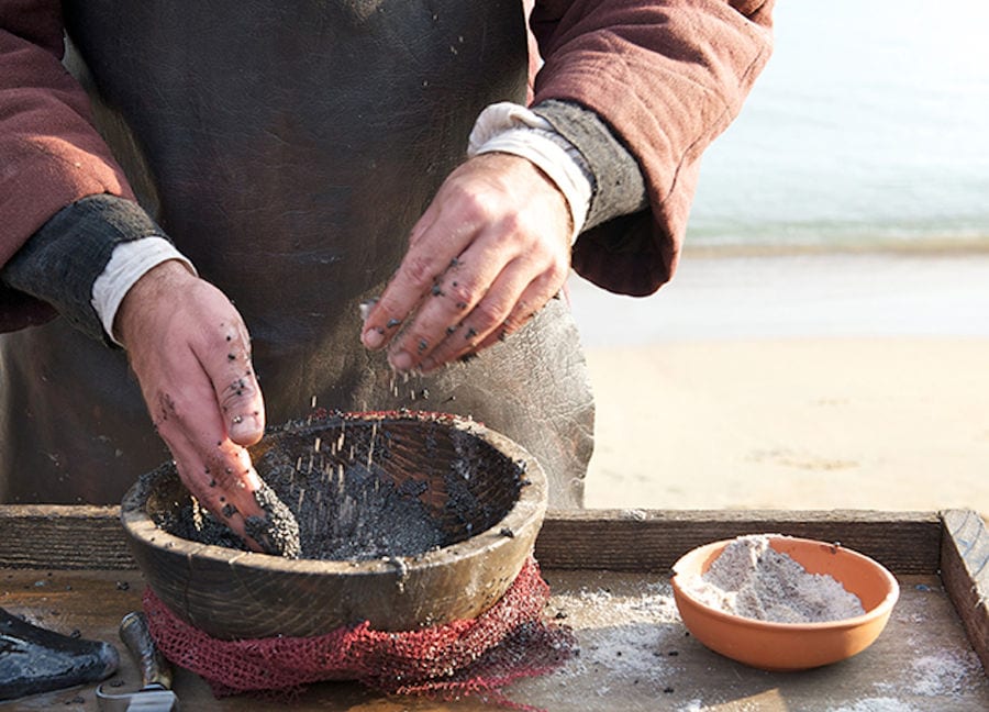 man putting salt on the caviar eggs and mixing them in wood bowl at 'Thesauri Caviar'